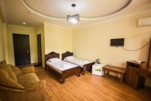 a living room with two beds and a tv at Hotel Otsneba in Kvariati