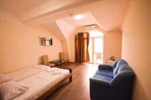 una camera da letto con un letto e un divano blu di Hotel Otsneba a Kvariati