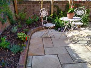 a garden with two chairs and a table and a patio at Tressell in Hastings