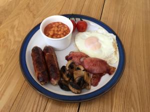 a plate of breakfast food with eggs sausage beans and tomatoes at Ebberley Escapes in Great Torrington