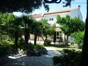 a large white house with trees in front of it at Apartman Miljenko - Matovica in Kampor
