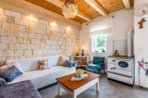 ein Wohnzimmer mit einem weißen Sofa und einem Tisch in der Unterkunft Holiday Home Frankica in Linardići