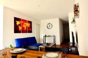 a living room with a table and a clock on the wall at Sweet Park Appartements in Rheinhausen