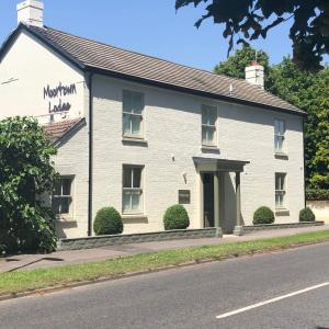 un edificio blanco al lado de una calle en Moortown Lodge B&B en Ringwood