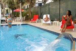 a group of women sitting in chairs in a swimming pool at Hotel Villa Marcella in San Vincenzo