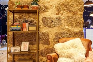 a living room with a chair and a book shelf at SUPERNOVA - Hostel & Café in Porto