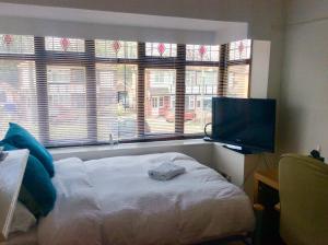a bedroom with a bed and a flat screen tv at Gateway House in Didcot