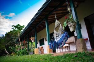 a porch of a house with a hammock on it at Casa El Cedro in Charalá