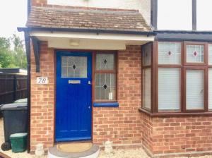 a brick house with a blue door and windows at Gateway House in Didcot