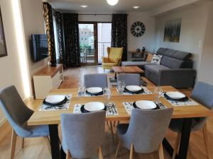 a dining room and living room with a table and chairs at Gdynia Orlowo Honey Apartment in Gdynia