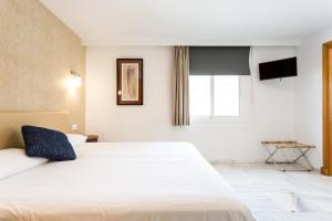 a bedroom with a large white bed and a window at Hotel Nómadas in Vejer de la Frontera