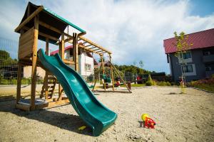 a playground with a slide and a play structure at Hotel Subcarpati in Curtea de Argeş