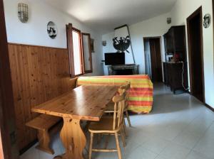 a wooden table and chairs in a room with a bed at Villetta Straccoligno in Capoliveri