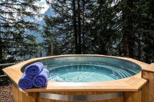 a hot tub with two towels sitting in it at Blatter's Arosa Hotel & Bella Vista SPA in Arosa
