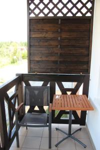 a wooden table and a bench on a porch at Apartament Nadmorski Zalewowa 12G in Sztutowo