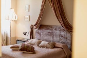 アッバディーア・サン・サルヴァトーレにあるAppartamento Biancospinoのベッドルーム1室(天蓋付きベッド、枕付)