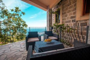 a patio with two chairs and a table with a bowl of pumpkins at Villa Ladera Lapcici in Budva