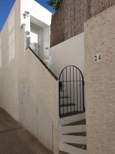 une porte sur le côté d'un bâtiment blanc avec des escaliers dans l'établissement Apt, Gengina, centrico con parking, à Cadaqués