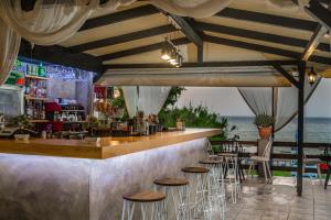 a bar with chairs and a counter with the ocean at Amarylis Beachfront Studios in Amoudi