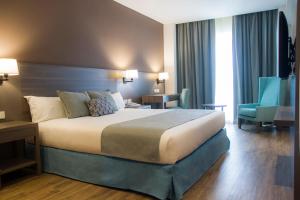 una habitación de hotel con una cama grande y una silla azul en Hotel Land Plaza La Plata, en La Plata