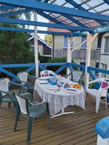 a table and chairs on a wooden deck at House Violeta in Nida