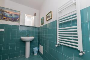 a bathroom with a sink and green tiles at H2.0 Portofino in Camogli