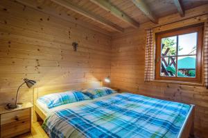 a bed in a wooden room with a window at Montana Bobrovec in Bobrovec