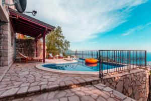 a swimming pool with an inflatablelatable boat on a patio at Villa Vistamar Lapcici in Budva