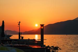 蒂瓦特Apartments Tramonto的船坞在水体上的日落