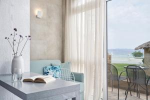 a table with a book on it next to a balcony at Antigoni Seaside Resort in Ormos Panagias