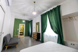 een slaapkamer met groene gordijnen en een bed en een stoel bij Monca's house in Vietri