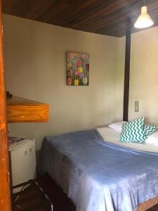um quarto com uma cama e um quadro na parede em Pousada Boldró Home em Fernando de Noronha