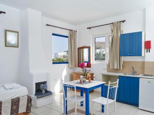 a kitchen with blue cabinets and a table and chairs at Lindos Athena in Lindos
