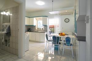 uma cozinha com mesa e cadeiras num quarto em Aegean Blue in Palio Kavala em Kavala