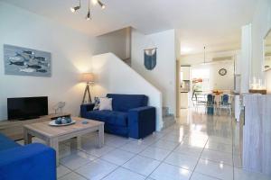 uma sala de estar com um sofá azul e uma mesa em Aegean Blue in Palio Kavala em Kavala