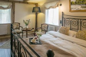 a bedroom with a bed with two chairs and a table at Raxti in Kuldīga