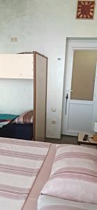 a bedroom with a bunk bed and a door at TJ Guest House in Makhinjauri