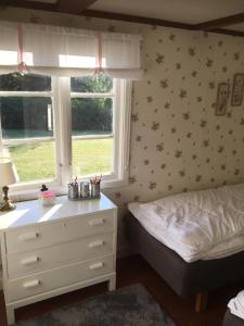 a bedroom with a bed and a dresser and a window at Tubbared. in Ullared