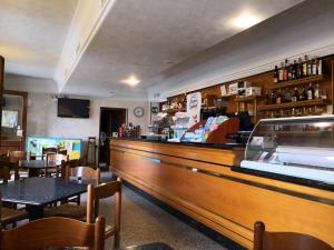 a bar in a restaurant with tables and chairs at Trattoria Bar Oasi in Pocenia