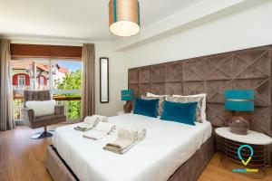 ein Schlafzimmer mit einem großen Bett und einem Stuhl in der Unterkunft Camilo Apartment in Porto