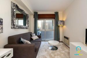 ein Wohnzimmer mit einem Sofa und einem Tisch in der Unterkunft Camilo Apartment in Porto