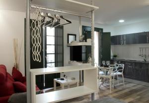 a kitchen and a living room with a table and a couch at Acio blanco. Loft en el Casco Histórico de Ourense in Ourense