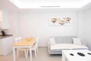 ein Wohnzimmer mit einem Sofa und einem Tisch in der Unterkunft Cubo's Apartamento Tivoli B4 in Benalmádena