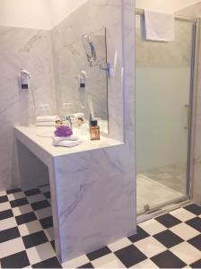 La salle de bains blanche est pourvue d'une douche et d'un lavabo. dans l'établissement Mare E Monti - Hôtel de Charme, à Feliceto