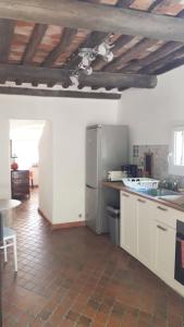eine Küche mit einem Kühlschrank aus Edelstahl und einem Tisch in der Unterkunft BANDOL Maison de Campagne in Bandol