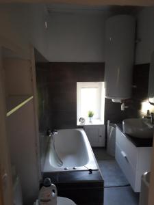 ein Bad mit einer Badewanne und einem Fenster in der Unterkunft BANDOL Maison de Campagne in Bandol