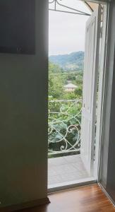 una puerta abierta a un balcón con vistas en TJ Guest House en Makhinjauri