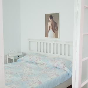 a bedroom with a bed and a picture on the wall at Old Town Apartament in Târgovişte