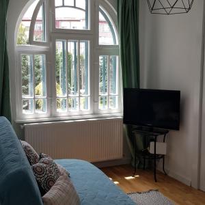 a living room with a large window and a television at Old Town Apartament in Târgovişte