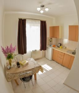 eine kleine Küche mit einem Tisch und einem Fenster in der Unterkunft Гранд Хостел in Czernowitz